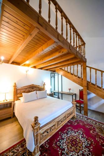 a bedroom with a large bed and a staircase at Hotel Gjirokastra in Gjirokastër