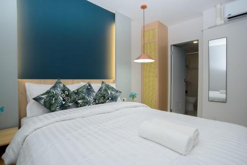 a bedroom with a large white bed with pillows at MINI Plume Minburi in Min Buri