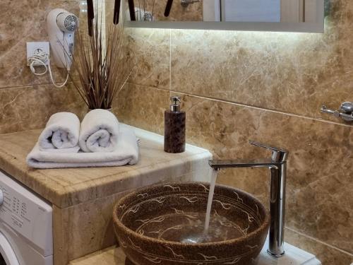 a bathroom with a sink and a washing machine at Marathon Studios & Apartments in Keri
