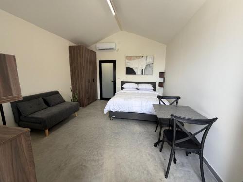 a bedroom with a bed and a couch and a table at טריו בכרמל in Dāliyat el Karmil
