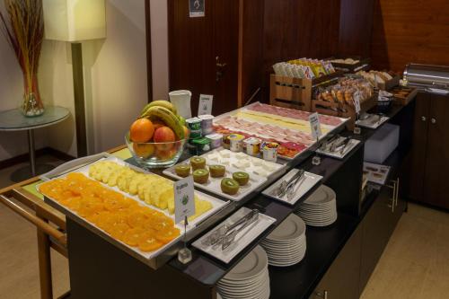 a buffet with fruit and other food on a table at Sercotel AB Arganda in Arganda del Rey