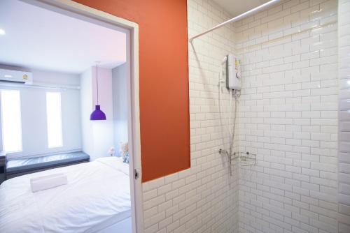 a bathroom with a bed and a shower with a mirror at MINI Plume Minburi in Min Buri