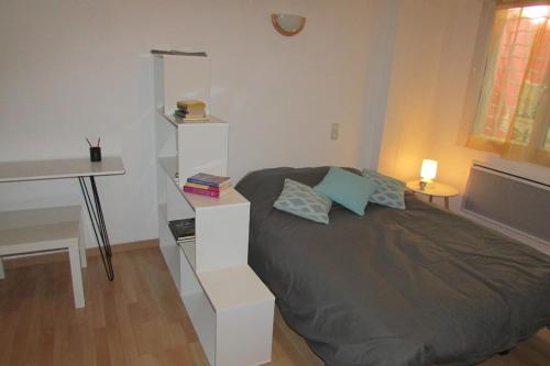 a bedroom with a bed with a white book shelf at studio centre de Gap in Gap