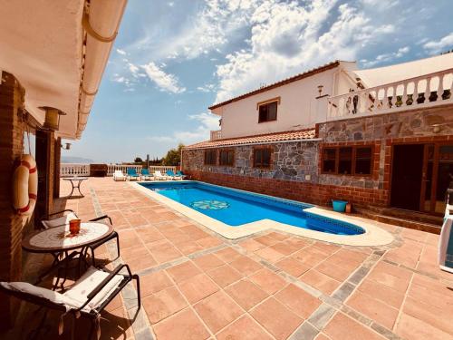 a patio with a swimming pool and a house at Natura Escapade in Torrox