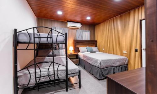 a room with two beds and a bunk bed at Apartamentos Javi in Tela