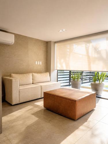a living room with a couch and a coffee table at Aurea Baulten by 123Quarto in Tambaú