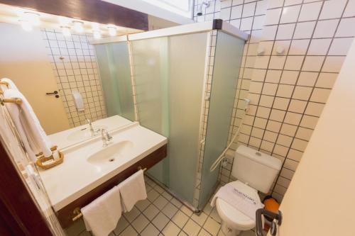 a bathroom with a sink and a toilet and a mirror at Xênius Hotel in João Pessoa