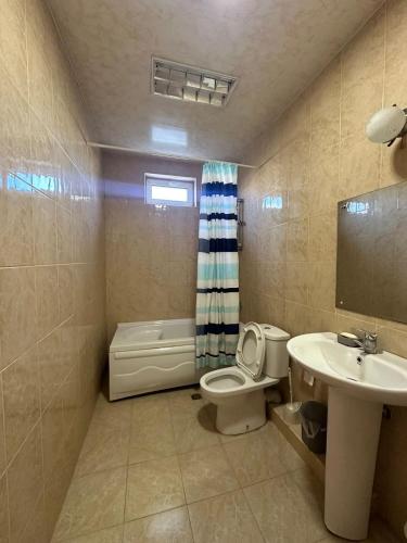 a bathroom with a toilet and a sink and a tub at Дом для отпуска в Гонио in Gonio