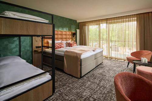 a bedroom with two bunk beds and a balcony at Hotel Gladbeck van der Valk in Gladbeck