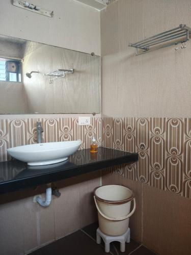 a bathroom with a sink and a mirror at The Alibag Beach hotel- Grantley in Alībāg
