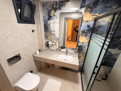 a bathroom with a sink and a toilet and a mirror at Ida Hotel in Marmaris