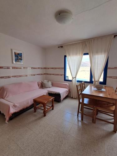a bedroom with two beds and a desk and a table at Apartamentos herederos Lm in Caleta de Sebo