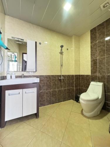 a bathroom with a toilet and a sink at Panoramic Mountains Hotel Guba in Qırızdǝhnǝ
