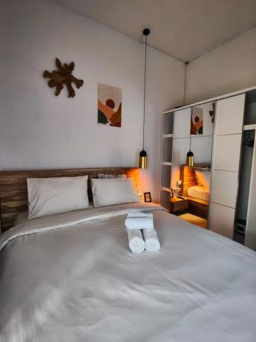 a bedroom with a bed with two white towels on it at Homestay Omah in Tabanan
