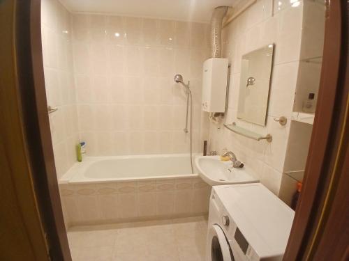 a white bathroom with a tub and a sink at Mieszkanie Piaskowa 22 in Kraśnik