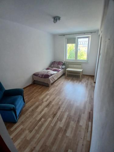 a bedroom with a bed and a couch and a window at Mieszkanie Piaskowa 22 in Kraśnik