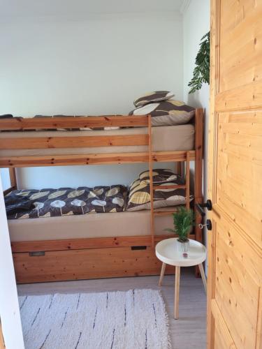 a bedroom with two bunk beds and a table at Vén Malom Apartman in Zalaszentgrót