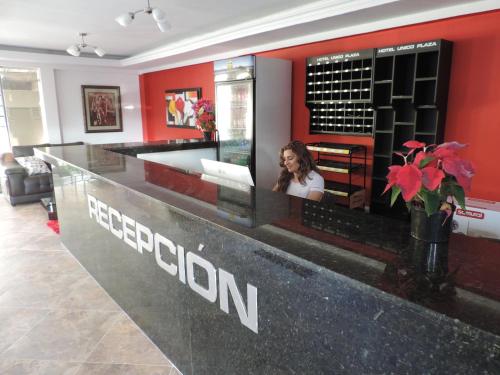 a woman sitting at a reception counter in a store at Hotel Único Plaza in Villavicencio