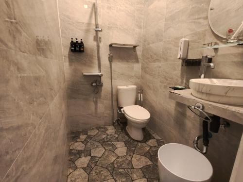 a bathroom with a toilet and a sink at Homestay Omah in Tabanan