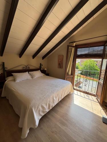a bedroom with a bed and a large window at Hotel Rural Huerta del Laurel in Monachil