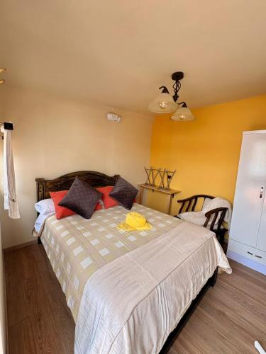 a bedroom with a bed with red pillows at Chakiñan Hospedaje & Eventos - Tumbaco in Tumbaco