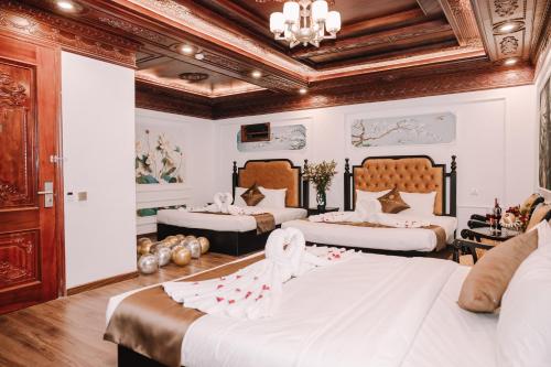 a bedroom with two beds and a chandelier at Doris Luxury Hotel in Hanoi