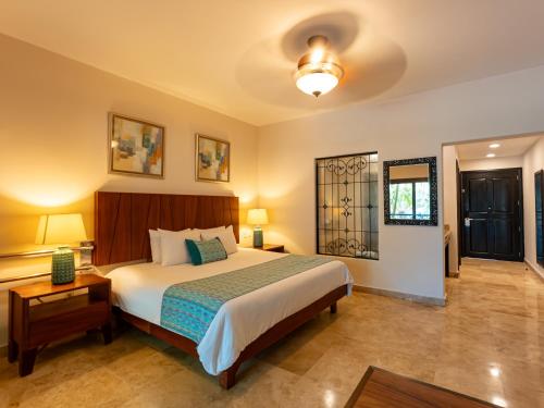 a bedroom with a bed and a table and lamps at Las Villas Hotel & Golf By Estrella del Mar in Mazatlán