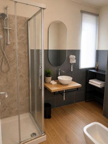 a bathroom with a glass shower with a sink and a mirror at Agriturismo Terra Madre in Rapallo
