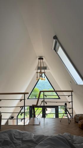 a large window in a room with a bed and a chandelier at Azad A-Frame in Şotrile