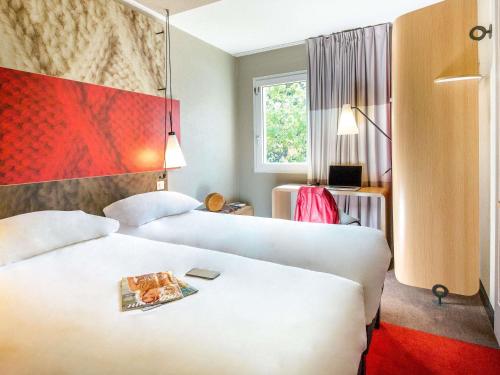 a hotel room with two beds and a window at ibis Saint-Omer Centre in Saint-Omer