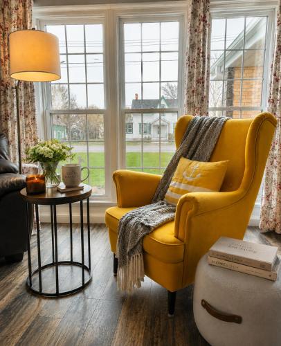 a living room with a yellow chair and a table at Downtown Picton Retreat - Near Sandbanks and Wineries in Picton