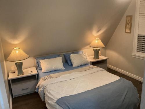 a bedroom with a bed and two lamps on tables at Granary Guest House in Goderich