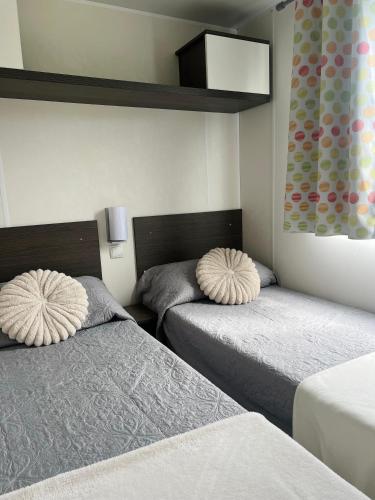 a bedroom with two beds with pillows on them at Camping benquerencia in Pena
