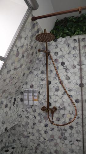 a shower in a bathroom with a tiled floor at Azad A-Frame in Şotrile