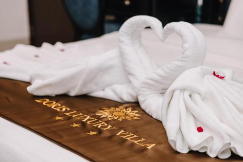 a table with swan towels and a happy anniversary sign at Doris Luxury Hotel in Hanoi