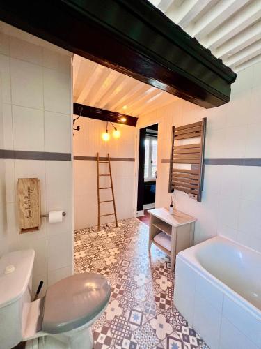 a bathroom with a tub and a toilet and a sink at Les Chambres du Clos De L'église in Senozan