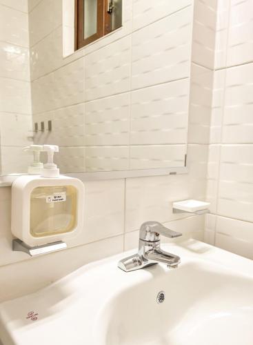a bathroom with a white sink and a mirror at Jian Stay Bora in Sin'gal