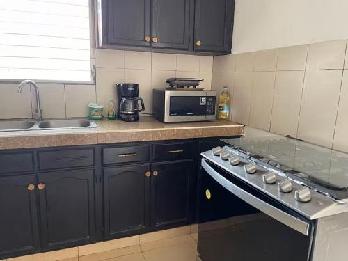 a kitchen with a stove and a microwave at Chitre Villa by Otium in Monagrillo