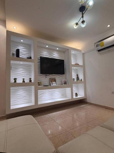 a living room with a television and white shelves at Chitre Villa by Otium in Monagrillo