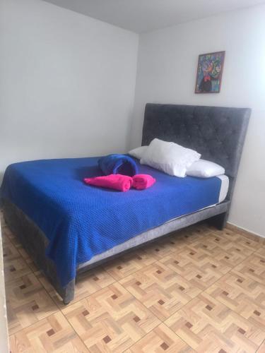 a bed with a blue blanket and two pillows on it at apartamento vacacional red in Salento