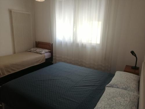 two beds in a small room with a window at B&B Il Maggiociondolo in Fontaniva