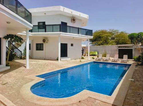 a villa with a swimming pool in front of a house at Izuba chambres avec vue sur piscine in Ngaparou