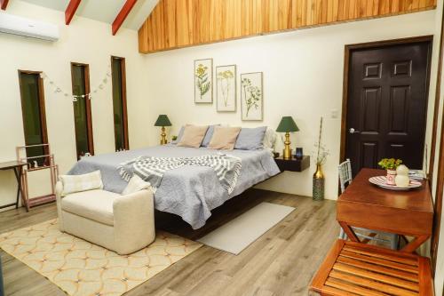 a bedroom with a bed and a chair and a table at Hotel Ecopaisajes- Lake-Premier-Resort in Santa Rita