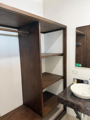 a bathroom with a wooden closet with a sink at Hotel LHM in Montería