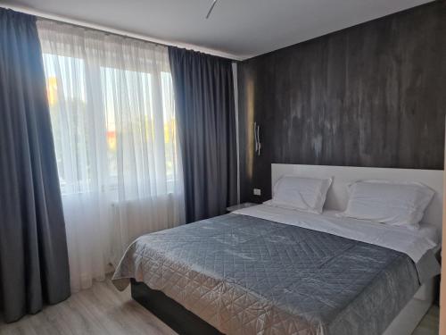 a bedroom with a bed and a large window at Iris central Mangalia 2 bedroom apartment in Mangalia
