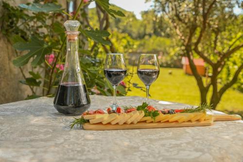 two glasses of wine and cheese on a table at Green Oasis Residence in Radanovići