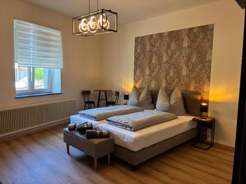 a bedroom with two beds and a table and a window at Pension Grum in Arnoldstein
