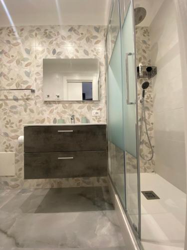 a bathroom with a glass shower and a mirror at L'Approdo di Re Ruggero in Cefalù