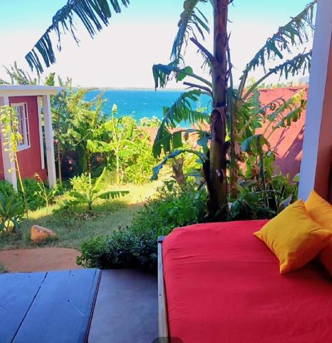 a bed in a room with a view of the ocean at Maisonnette en bord de mer in Antsiranana