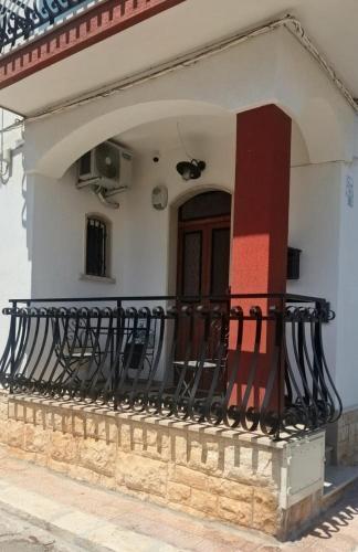 a house with a balcony with a door at Dimora Egnazia in Savelletri di Fasano